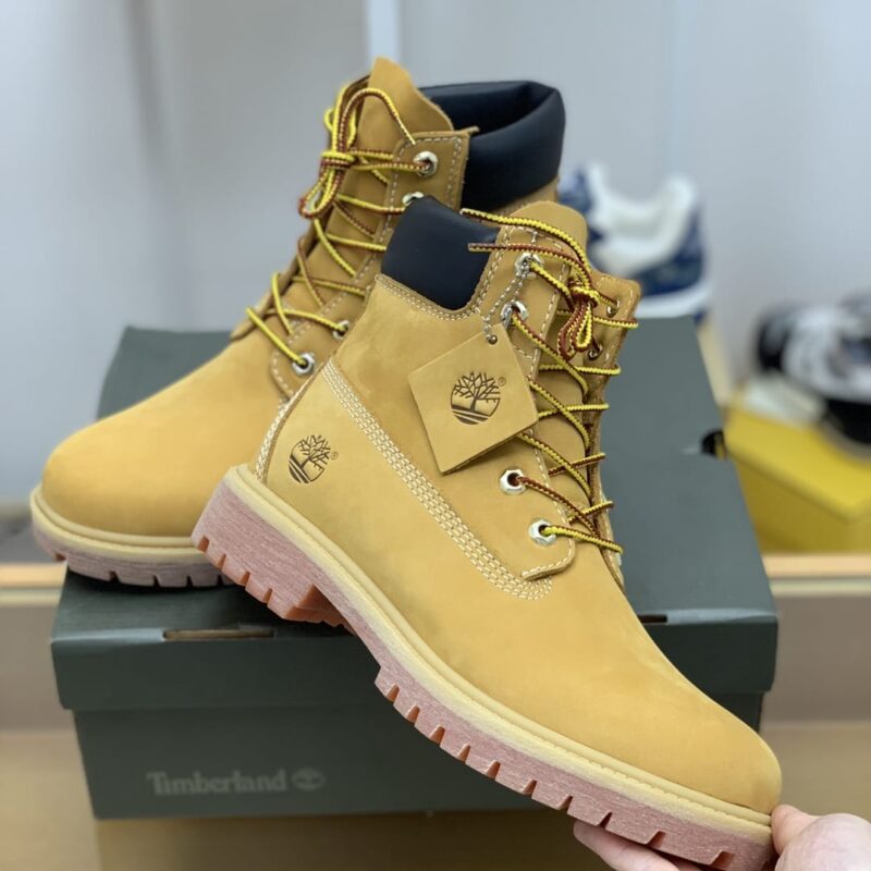 Timberland 采用米黄色磨砂皮,并以白色缝线和侧边烫印字母情侣款靴子